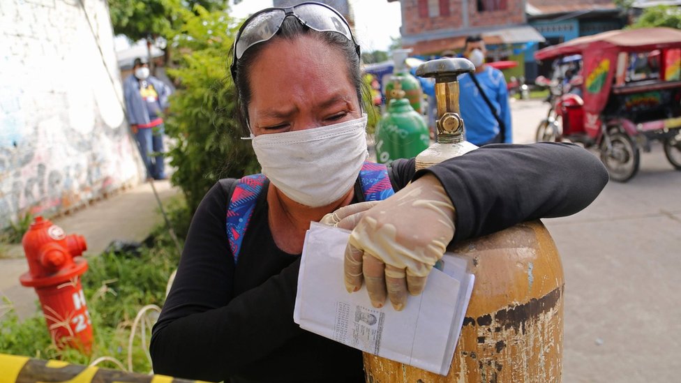 A relative of a COVID-19 patient queues to recharge oxygen tanks for their loved ones at the regional hospital in Iquitos, the largest city in the Peruvian Amazon, Peru