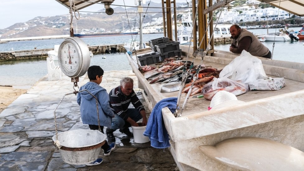 A fisherman cleans fish on May 26, 2020 in Mykonos, Greece