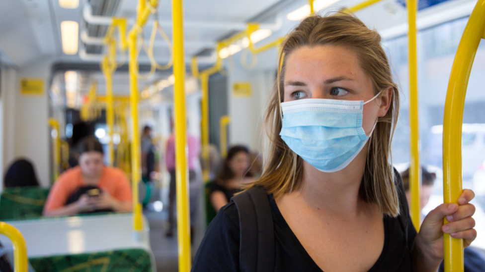 žena s maskom u autobusu