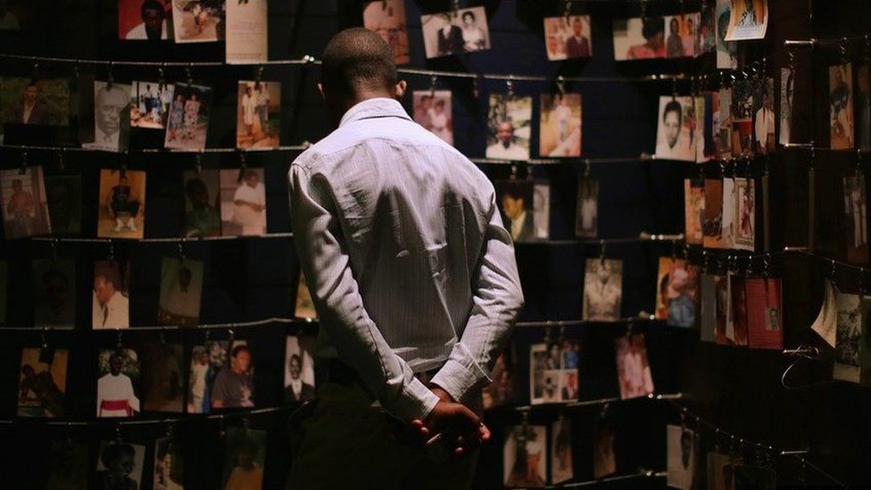 Man looking at pictures of some of the victims of the 1994 Rwandan genocide