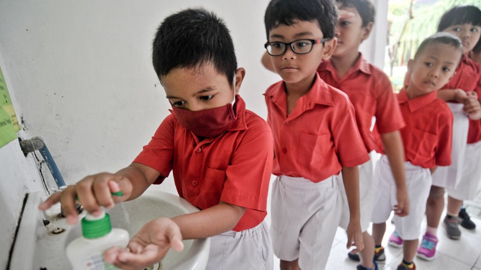 Children queuing up to wash their hands