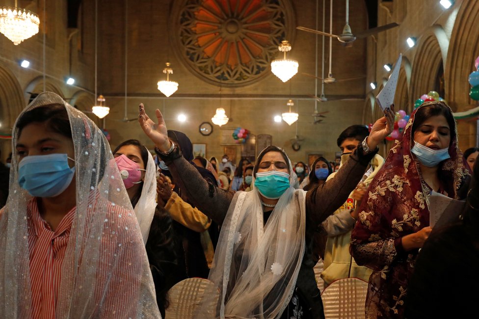 Women wear face masks as they pray during a Christmas Eve Mass in St Andrew's Church in Karachi, Pakistan. Photo: 24 December 2020