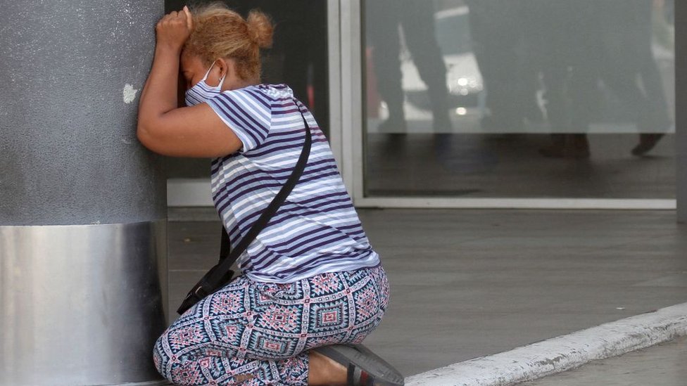 A woman on her knees, crying.