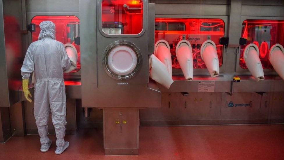 An employee in protective gear works on an assembly line at India's Serum Institute in Pune, January 2021