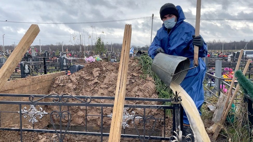 Cemetery worker prepares grave in Vologda