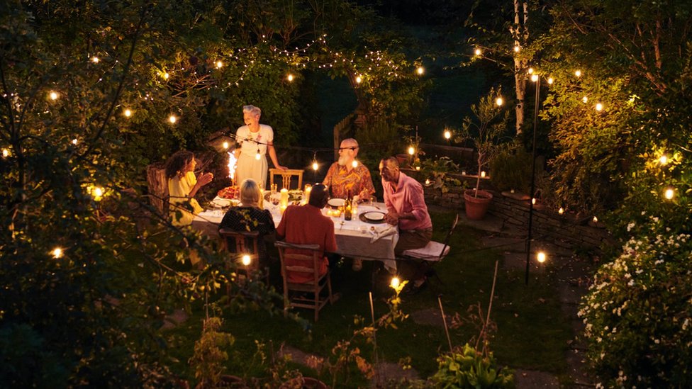 Friends talking and dining outside on a warm summers evening