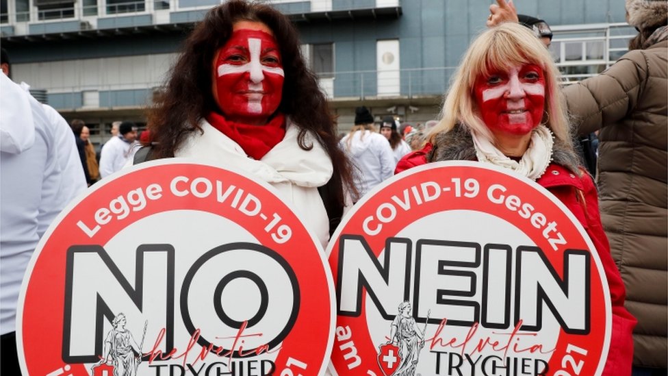 Demonstrators hold placards as they gather to protest against a planned coronavirus disease (COVID-19) law of the Swiss government in Zurich, Switzerland November 20, 2021