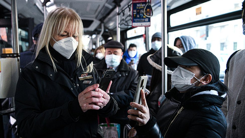 An official checks Covid-19 health passes of passengers on a bus in Italy